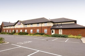 A hotel with multiple floors, a parking lot, and a "SLOW" marking on the road. - Premier Inn Taunton Central - North (Taunton)