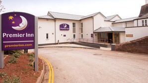 A Premier Inn hotel entrance with a sign, a staircase leading to the entrance, and a parking area. - Premier Inn Paignton - Goodrington Sands (Paignton)