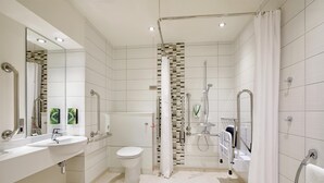 Ein modernes Badezimmer mit Dusche, Toilette und zwei Waschbecken.