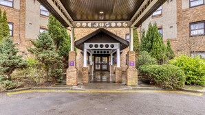 A building entrance with a covered walkway, brick walls, and a central door. - Premier Inn Glasgow Airport (Paisley)