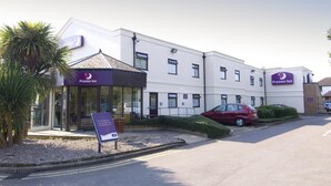 A Premier Inn hotel with a modern design, a covered entrance, and a parking area with cars. - Premier Inn Gloucester - Longford (Gloucester)