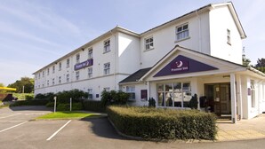 A hotel with a white exterior, a prominent 'Premier Inn' sign, and a parking lot. - Premier Inn Cheltenham Central - West/A40 (Cheltenham)