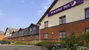 Un hotel con un cartello ben visibile 'Premier Inn', facciata in mattoni, numerose finestre e un parcheggio.