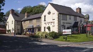 The Burnbrae, a traditional stone building with a signboard, a pub sign, and a bench outside. - Premier Inn Glasgow - Bearsden (Glasgow)