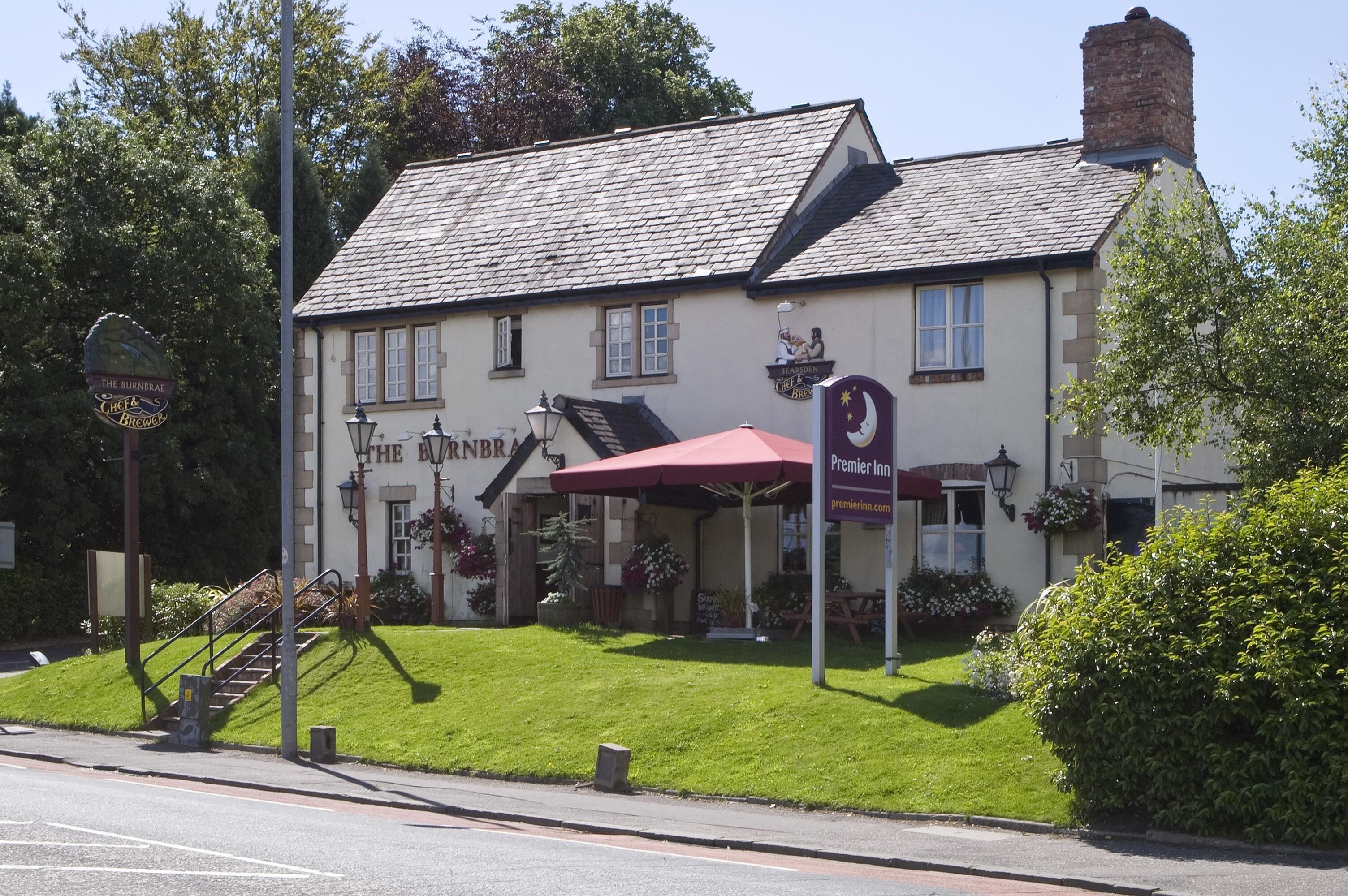 Un edificio tradicional con un letrero que dice 'The Burntree' y 'The Inn of the Black Horse'.