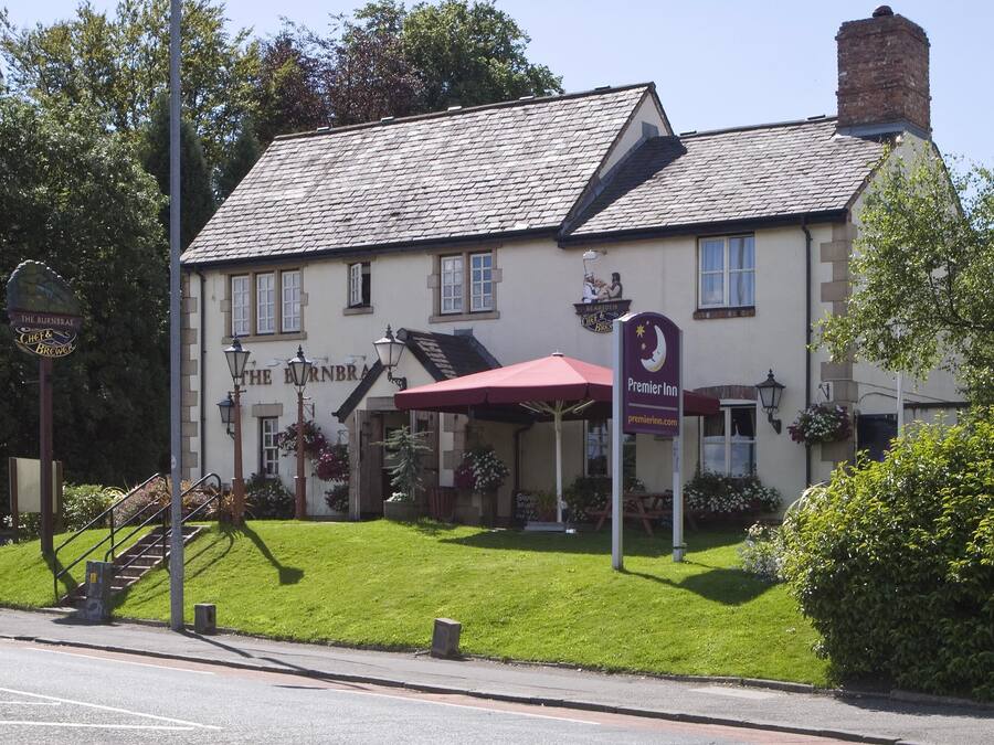 Un edificio tradicional con un letrero que dice 'The Burntree' y 'The Inn of the Black Horse'.