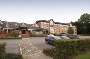 A hotel with a parking lot, a sign for 'The Park,' and a building with a sign for 'Premier Inn.' - Premier Inn Harrogate South (Harrogate)