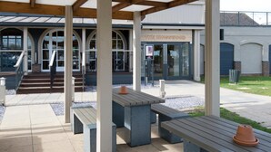 A covered outdoor area with benches and a building entrance labeled 'The Kingswood.' - Premier Inn Hull North (Hull)