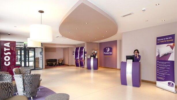 A hotel lobby with a reception desk, seating area, and a Costa sign. - Premier Inn High Wycombe Central (High Wycombe)