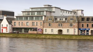 A riverside hotel with a modern building, a traditional brick building, and a sign for 'Premier Inn'. - Premier Inn Inverness Centre - River Ness (Inverness)