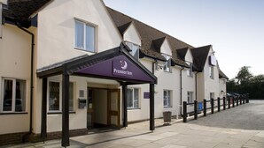 L’entrée d’un hôtel, avec une enseigne indiquant « Premier Inn », une allée couverte et un espace de stationnement.