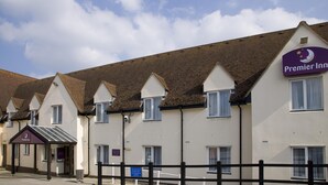 Une rangée de bâtiments blancs aux toits en forme de flèche, avec une enseigne indiquant « Premier Inn ».