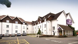 Ein Hotel mit einem gut sichtbaren Premier Inn Schild, einem Parkplatz mit ausgewiesenen Behindertenparkplätzen und einem Gebäude mit mehreren Fenstern und einem Satteldach.