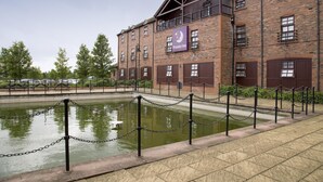 Ein Backsteinhaus mit einem Schild für Premier Inn, einem Wasserspiel und einem verschlossenen Bereich.