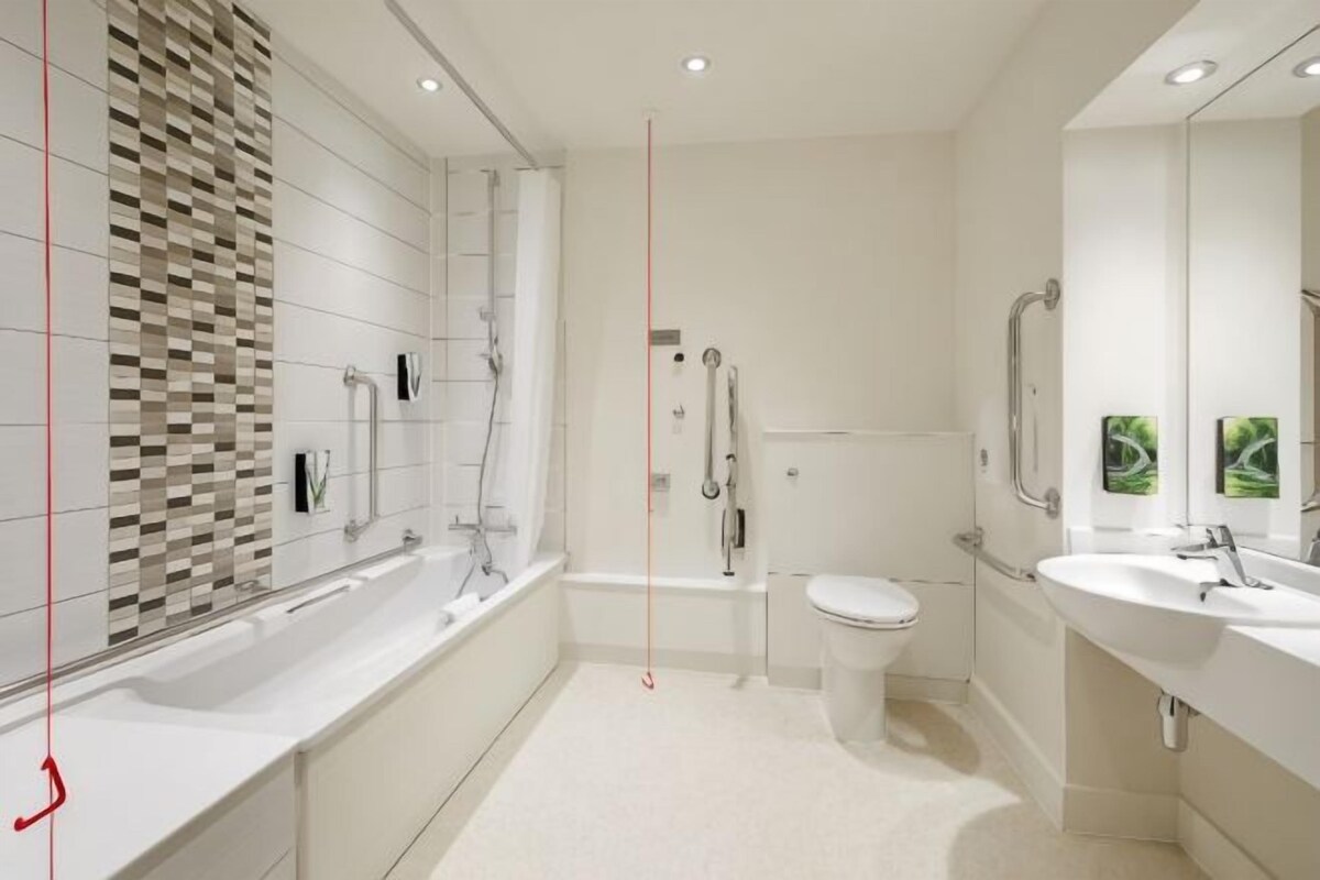 A modern bathroom with a bathtub, toilet, and sink.