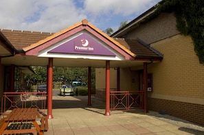A hotel entrance with a covered waiting area, a signboard, and a parking lot. - Premier Inn Pontefract North (Knottingley)