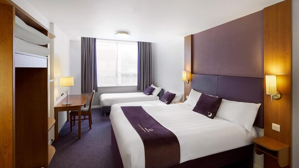 A hotel room with two beds, a desk, and a wardrobe. - Premier Inn Rotherham East - M18/M1 (Rotherham)