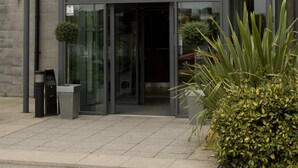 A hotel entrance with a glass door, a covered waiting area, and a logo above the entrance. - Premier Inn Sheffield Meadowhall (Sheffield)