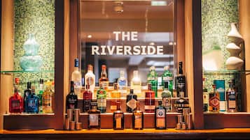 A bar with a variety of liquor bottles and a sign that reads 'THE RIVERSIDE'.