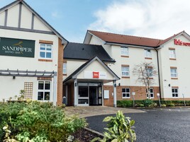 A hotel with a sign for 'Sandpiper Bistro-Bar' and 'Ibis Coleraine.'