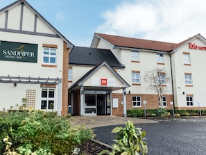A hotel with a sign for 'Sandpiper Bistro-Bar' and 'Ibis Coleraine.'
