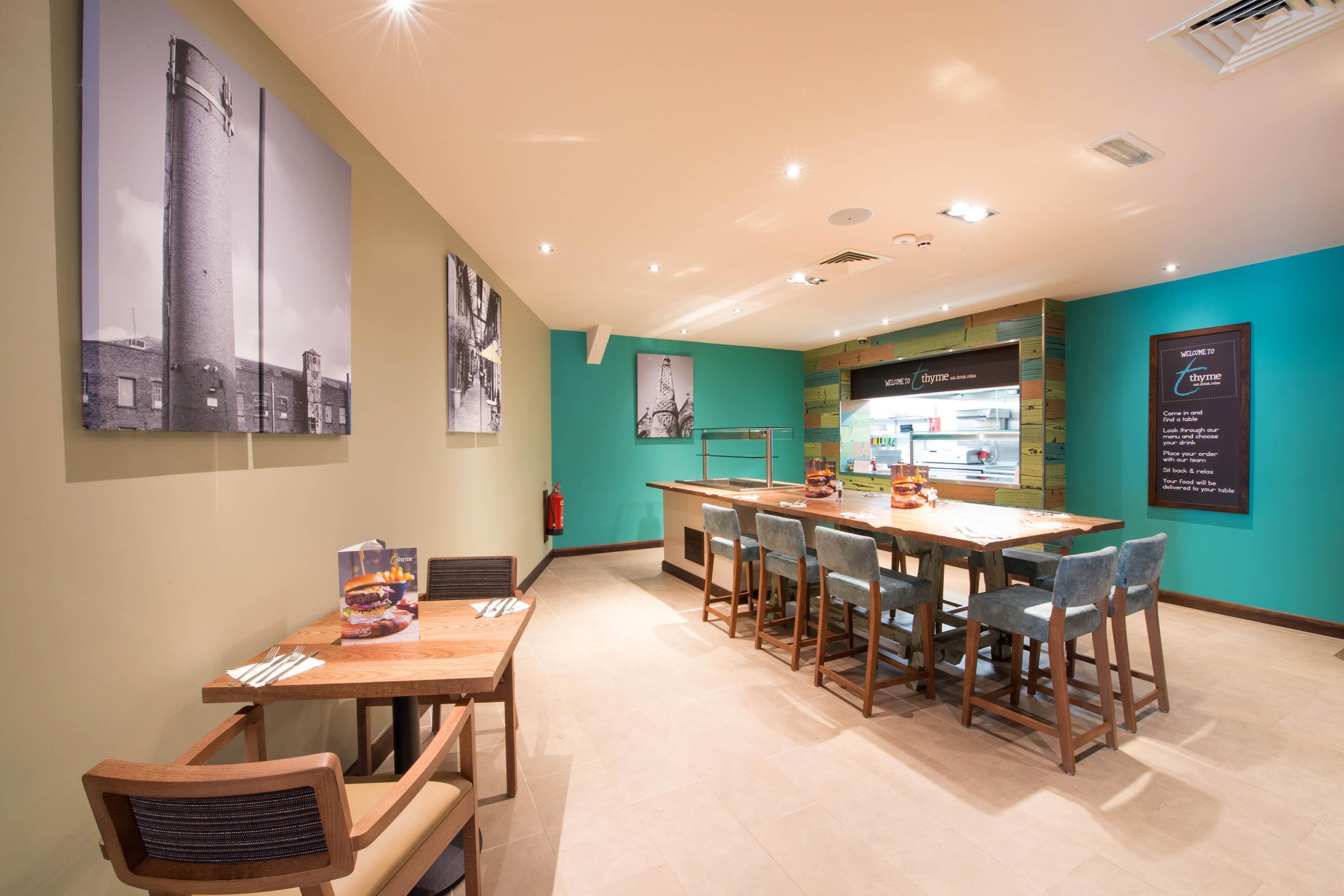 Un restaurant doté d’une longue table et de nombreuses chaises, d’un bar et d’œuvres d’art murales.