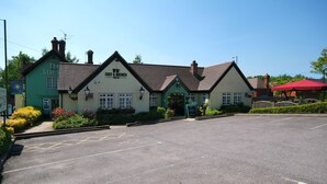 A two-story building with a pub sign, a sign for a chef and brewer, and a welcoming sign. - Premier Inn East Grinstead (East Grinstead)