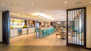 A bar area with stools, a counter, and a staircase. - Premier Inn Lichfield City Centre (Lichfield)