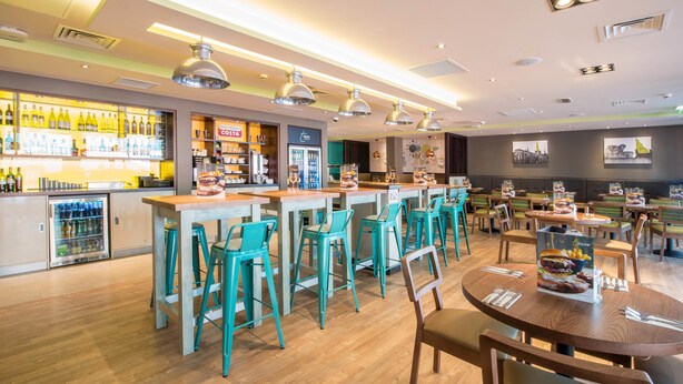 A restaurant with multiple seating areas, bar counters, and a variety of food and drink options.