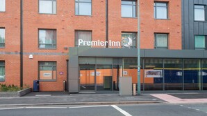 A Premier Inn hotel with a brick facade, large windows, and a modern entrance.