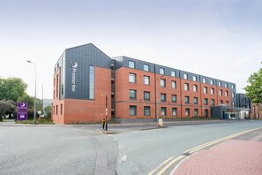 A modern hotel with a brick facade, multiple windows, and a prominent entrance. - Premier Inn Lichfield City Centre (Lichfield)