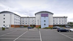 A hotel with a sign for Premier Inn, multiple parking spaces, and a clear sky. - Premier Inn London Enfield (Enfield)