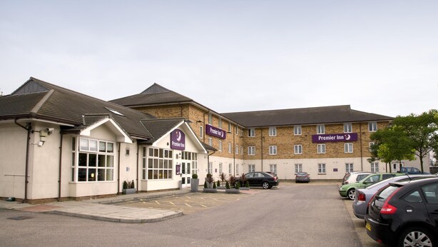 Un hotel con un parcheggio, un edificio con la insegna Premier Inn e diverse auto parcheggiate.