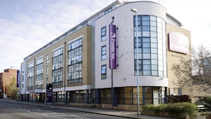 A modern building with a curved facade, large windows, and a prominent Premier Inn sign. - Premier Inn London Kew Bridge (Brentford)