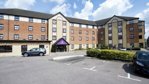 A multi-story hotel with a brick facade, a parking lot, and a clear sky. - Premier Inn London Edgware (Edgware)