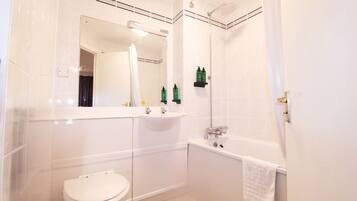 A bathroom with a toilet, sink, and bathtub.