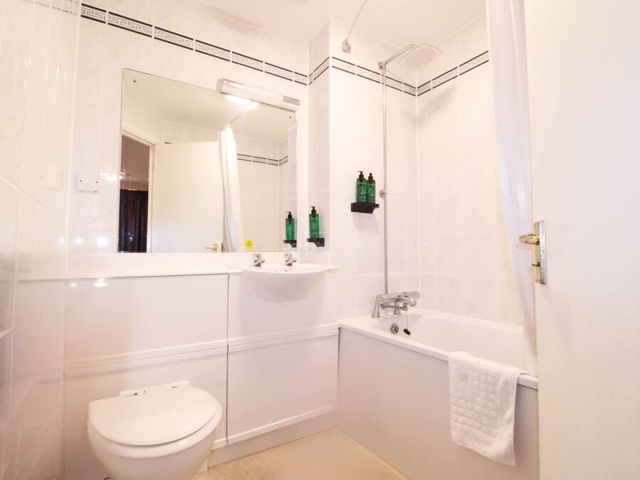 A bathroom with a toilet, sink, and bathtub.