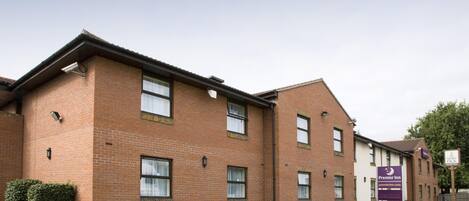 A brick building with multiple windows and a sign for Premier Inn.