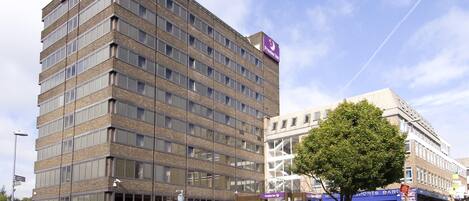 A multi-story hotel with a prominent Premier Inn sign, large windows, and a visible entrance.