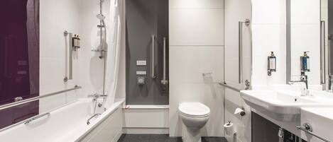 A modern bathroom with a bathtub, toilet, and shower.