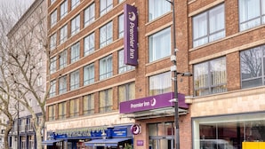 Ein mehrstöckiges Hotel mit einem gut sichtbaren 'Premier Inn'-Schild, großen Fenstern und einer sichtbaren Fassade mit einem blauen Vordach.