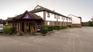 Een hotel met een opvallend bord, een parkeerplaats en een goed onderhouden gevel.