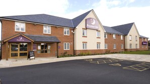A Premier Inn hotel with a brick facade, multiple windows, and a parking lot with disabled parking spaces. - Premier Inn Rhuddlan (Rhuddlan)