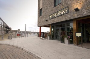 A building with a sign reading 'Yr Harbwr' and a waterfront view. - Premier Inn Caernarfon (Caernarfon)