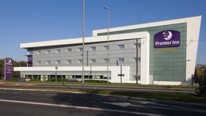 Ein modernes Hotel mit einem gut sichtbaren Premier Inn Schild, einer glatten Fassade und einem großen Parkplatz.
