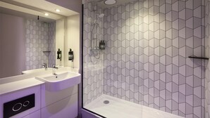 Un bagno moderno con doccia, due lavandini e uno specchio grande.