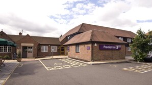 A brick building with a sign for 'Premier Inn' and a parking area with disabled parking spaces.