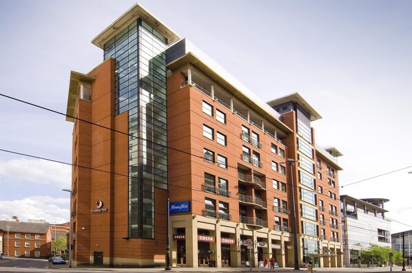 A multi-story hotel with a prominent glass facade, multiple balconies, and signage for Costa and Premier Inn. - Premier Inn Manchester Central (Manchester)