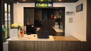 A check-in counter with a laptop, a computer mouse, and a vase of flowers. - Plaza Hotel, Chorley, Sure Collection by Best Western (Chorley)