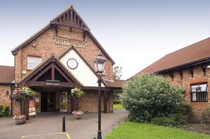 A brick building with a sign reading 'Stable Gate' and 'Welcome'. - Premier Inn Manchester - Denton (Manchester)